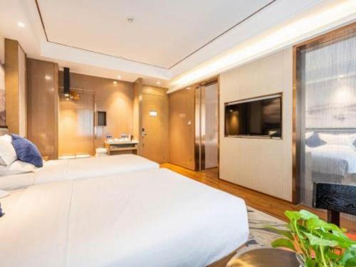 a large bedroom with a large bed and a television at East Queen Hotel (Xi'an Beimen Metro Station) in Xi'an