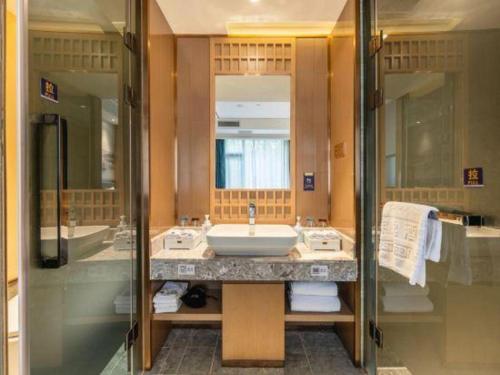 a bathroom with a sink and a mirror at East Queen Hotel (Xi'an Beimen Metro Station) in Xi'an