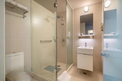 a bathroom with a shower and a toilet and a sink at Jinjiang Inn Select Xuzhou Suning Plaza Jinguang East Road in Xuzhou
