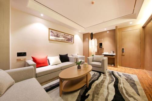 a living room with a couch and a table at East Queen Hotel (Xi'an Beimen Metro Station) in Xi'an