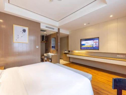 a bedroom with a bed and a tv on the wall at East Queen Hotel (Xi'an Beimen Metro Station) in Xi'an