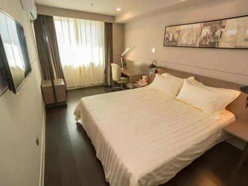 a hotel room with a large bed and a desk at Jinjiang Inn Style Shijiazhuang Zhongshan Xi Road Yuxi Park in Shijiazhuang