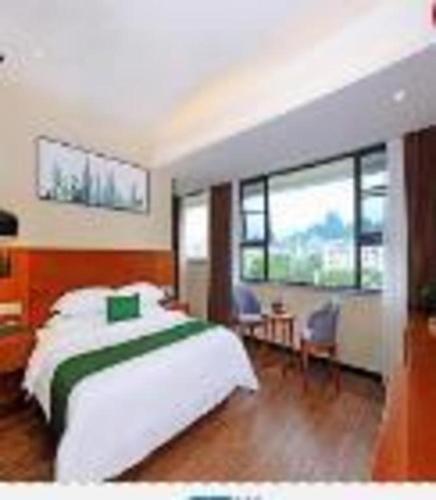 a bedroom with a large white bed and windows at Immersing Hotel Guilin Two Rivers and Four Lakes Dongxi Alley in Guilin