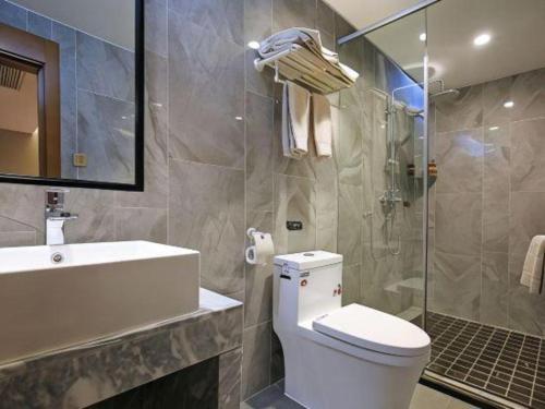 a bathroom with a toilet and a sink and a shower at Immersing Hotel Guilin Two Rivers and Four Lakes Dongxi Alley in Guilin