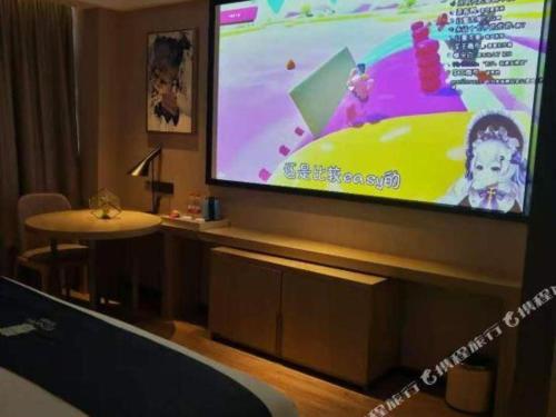 a large screen television in a room with a table at Echarm Hotel Nanning Chaoyang Square River View in Nanning