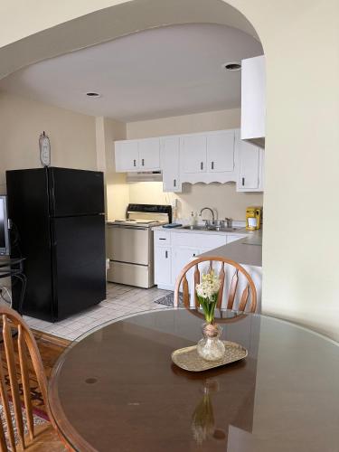 a kitchen with a table and a black refrigerator at Historic LaSalle Downtown in Fort Wayne