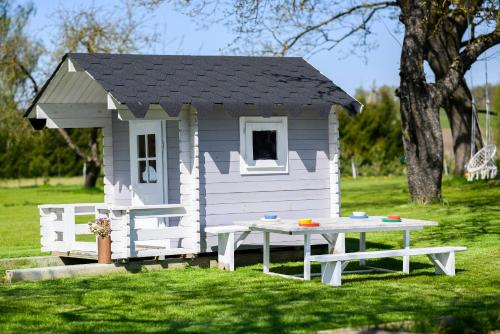 a small play house with a picnic table in the grass at Arimaičių kaimo sodyba in Arimaičiai