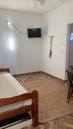 a bedroom with a bed and a tv on a wall at Wonders of Arraial Loft 7 in Arraial do Cabo