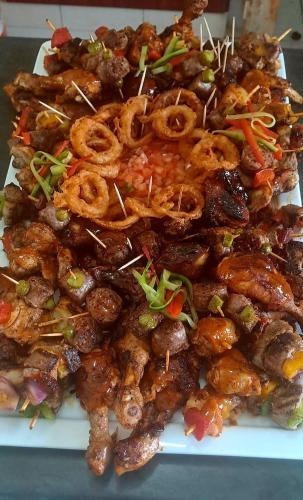 a pile of food on a white plate at Qabuleka BnB in Nongoma
