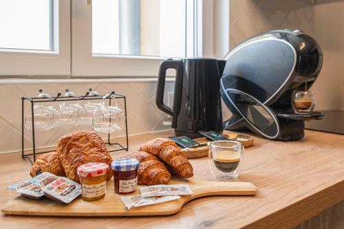 un tavolo con pane e croissant e una macchina per il caffè di Love Room 91 avec Jacuzzi XXL - 15min Orly - 30 min Paris a Longjumeau