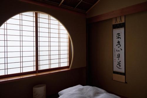 a bedroom with two windows and a bed with white sheets at unsui 武雄蓬莱町 雲水 in Takeo