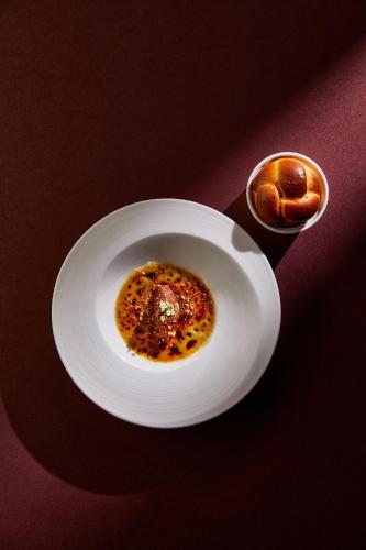 a white plate with a piece of food on a table at The Landis Taipei in Taipei