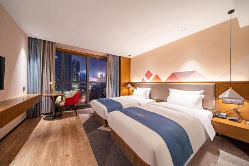 une chambre d'hôtel avec deux lits et un bureau dans l'établissement Borrman Hotel Ji'nan Aoti Center East Provincial Hospital, à Jinan