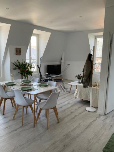 una sala de estar con una mesa y sillas en Villa Odette beach, en Villers-sur-Mer
