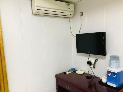 a room with a desk with a tv and a computer at OYO Huifeng Business Hotel in Lanzhou