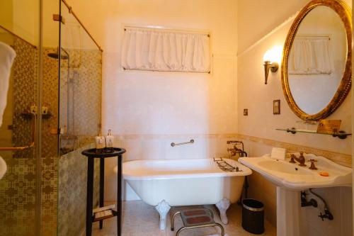 a bathroom with a tub and a sink and a mirror at Dalat Palace Heritage Hotel in Da Lat