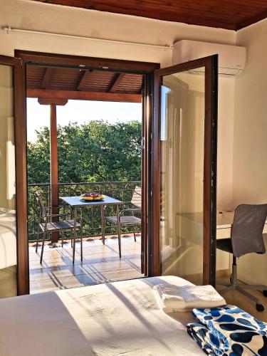 a bedroom with a bed and a balcony with a table at Step to Paradise in Pelion in Agios Ioannis Pelio