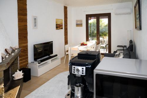 a living room with a television and a kitchen with a table at Step to Paradise in Pelion in Agios Ioannis Pelio