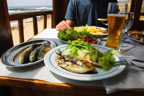 Una mesa con platos de comida y un vaso de cerveza. en Lovely Chalet In The Isle Of Wight, Sleeps 6 Ref 97009S, en Sandown