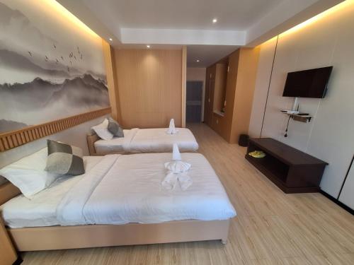 a hotel room with two beds and a television at Hoongthip hotel in Savannakhet