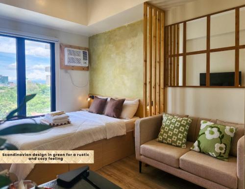 a bedroom with a bed and a couch and a window at The Traveller's Haven at the Median in Cebu City
