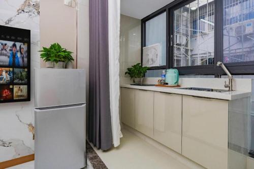a kitchen with a white refrigerator and a window at Super 8 Hotel Chengdu Kuan Zhai Zane Huapaifang in Chengdu