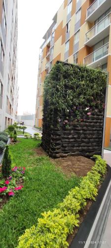 a garden in front of a building with flowers at Pacific Apartamento Surco in Lima