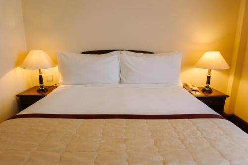 a bed in a hotel room with two lamps at Du Parc Hotel Dalat in Da Lat