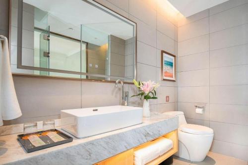 a bathroom with a sink and a toilet at Vienna Hotel Tianjin Chentangzhuang Metro Station in Tianjin