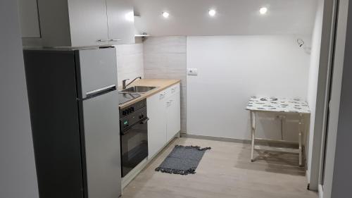 a kitchen with a black refrigerator and a sink at Apartmani Kriva Drina in Okletac