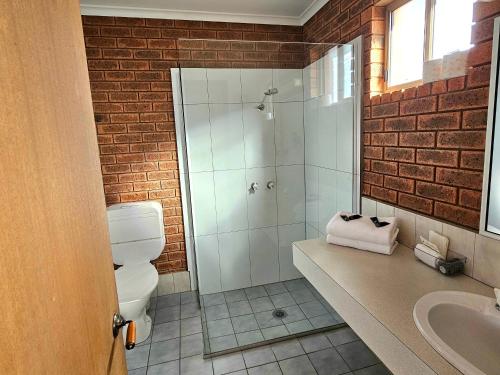 a bathroom with a shower and a toilet and a sink at Bridge Motor Inn Tocumwal in Tocumwal