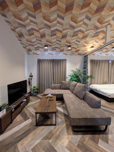 a living room with a couch and a tv at Bay view Sotetsu no yu in Beppu