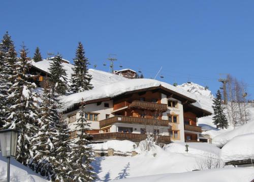 un edificio cubierto de nieve con árboles nevados en Appart Andrea, en Lech am Arlberg