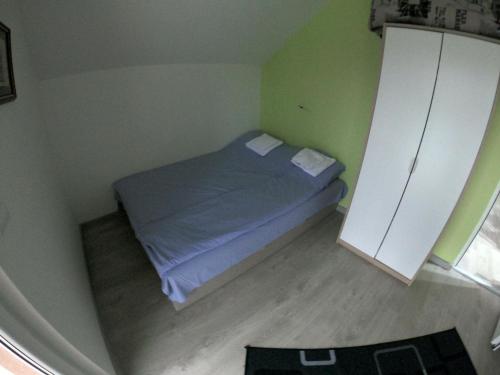 a small bedroom with a bed in a green room at Apartmani Kriva Drina in Okletac