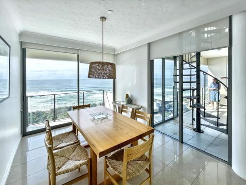 una sala da pranzo con tavolo e vista sull'oceano di Majorca Isle Beachside Resort a Maroochydore