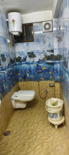 a bathroom with a toilet and a fish mural at Traveller Guest House in Varanasi