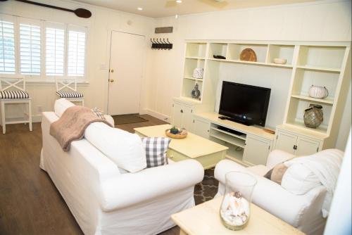 a living room with white furniture and a flat screen tv at 4980 Sandyland Road #216 in Carpinteria