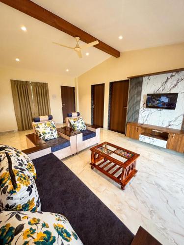 a living room with two couches and a coffee table at The Mountain Paradise Mahabaleshwar in Kelghar