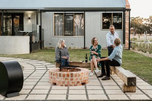 a group of people sitting on a bench in a yard at Harry's On Moodemere in Rutherglen