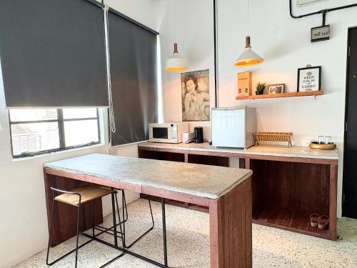 a kitchen with a wooden table and a microwave at Kim Haus Loft in George Town
