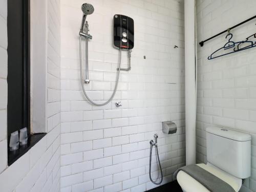 a white bathroom with a shower and a toilet at Kim Haus Loft in George Town