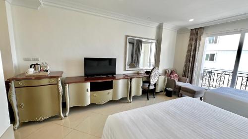 a hotel room with a bed and a television at LK CRYSTAL Ville PATTAYA in Ban Chek