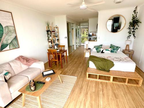 a living room with a bed and a couch at Island Views in Airlie Beach
