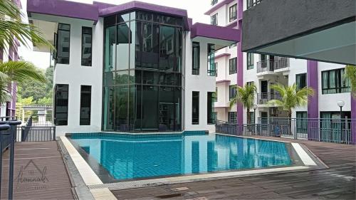 a swimming pool in front of a building at Homestay Ayer Keroh, MiTC , UTEM, Bukit Beruang in Ayer Keroh