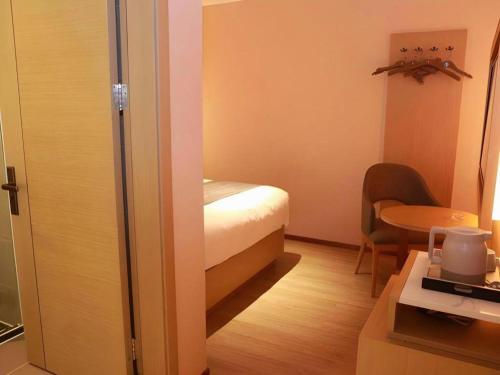 a small room with a bed and a table at Lavande Hotel Shenzhen East Gate Wanxiang City Guomao Metro Statipn in Shenzhen