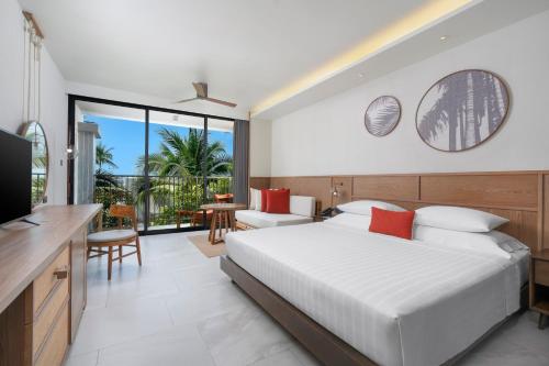 a hotel room with a bed and a television at The Culture Samui in Bangrak Beach
