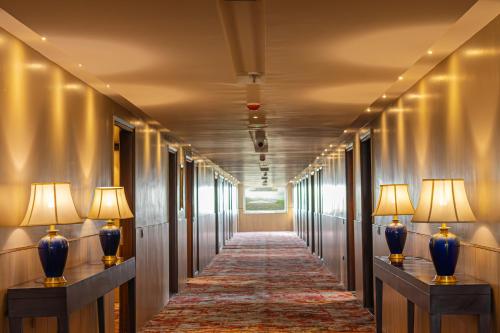 a hallway with two blue vases and two lamps at The Lalita Grand Mathura- Vrindavan in Mathura