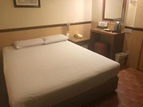 a bedroom with a large white bed in a room at Four Chain View Hotel in Singapore