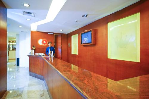 a man standing at a bar in a hotel lobby at Collection O 166 Hotel Princess in Palembang