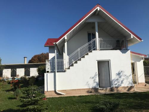 a white house with stairs and a balcony at Fantastic camp in Piteşti